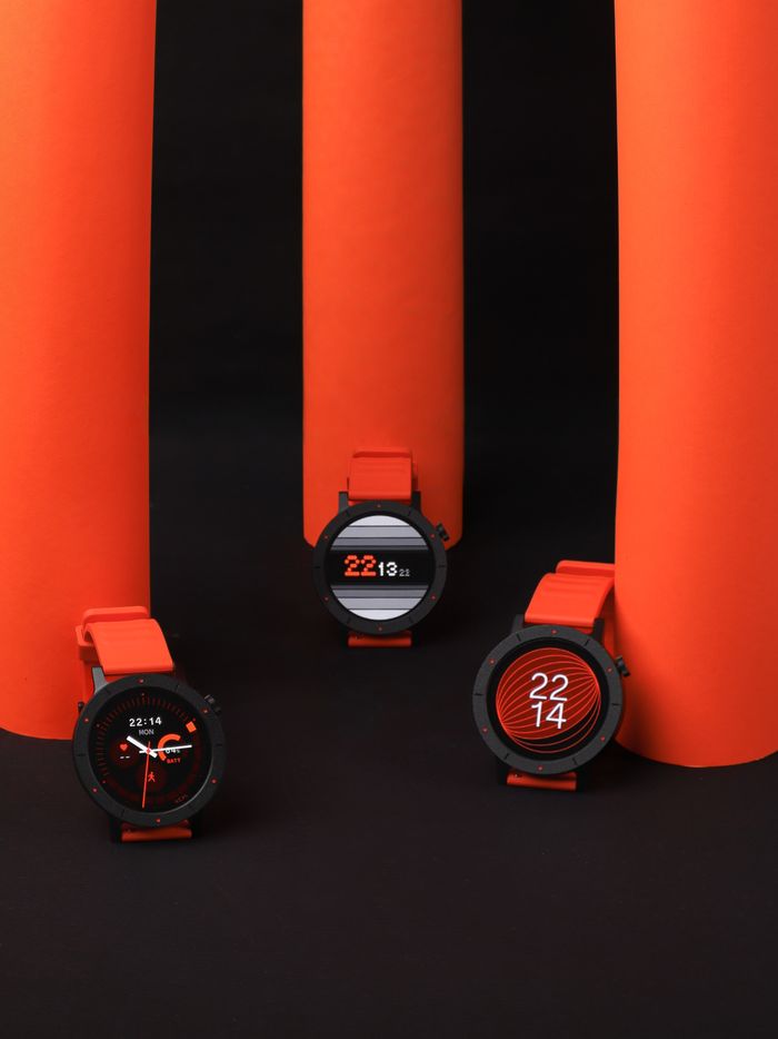 Three stylish smartwatches with red bands showcased against an orange and black modern backdrop.
